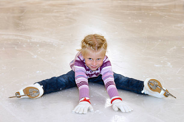 a menina sentada no gelo, patinação no gelo. - playground snow winter little girls - fotografias e filmes do acervo