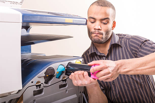 istock man changing magenta cartridge in color printer 505848364
