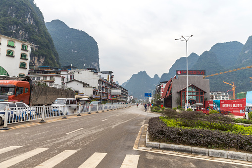 Yangshuo, guangxi, China - December 19, 2015:Street view of Yangshuo, a lot restaurants and stores on sides, a lot car on the street. incidental people on the background.