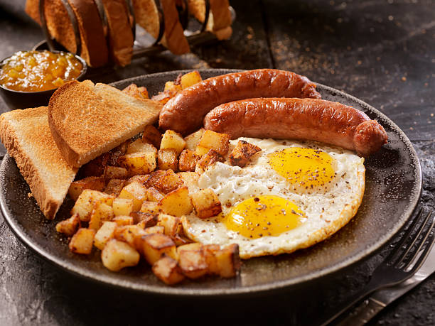 bue prima colazione con uova e salsiccia - breakfast eggs fried egg sausage foto e immagini stock