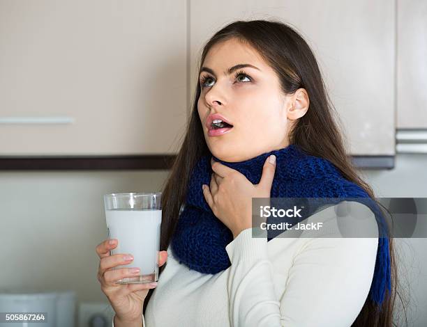 Girl With Throat Pain Gargling Throat In Kitchen Stock Photo - Download Image Now - Gargling, Throat, Women