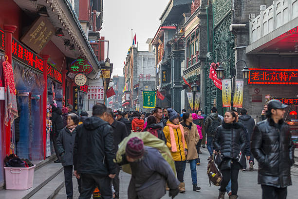 China popular restaurant alley colourful neon signs at Beijing People eating at a pavement cafe in the narrow hutongs of the Qianmen  markets illuminated by colourful neon signs in the heart of Beijing, China. chinese ethnicity china restaurant eating stock pictures, royalty-free photos & images