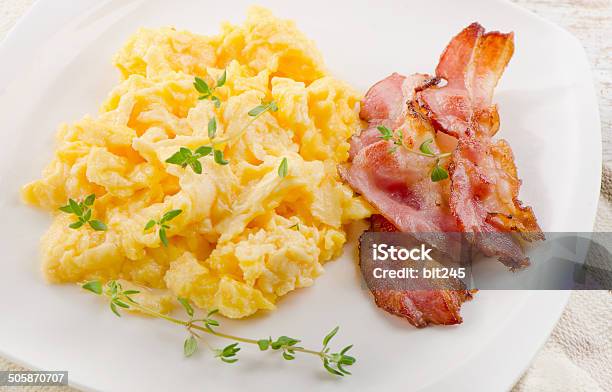 Plate with scrambled egg and bacon on white background Stock Photo - Alamy