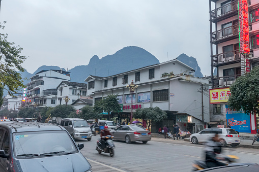 Yangshuo, Guangxi, China - December 19, 2015: Street view of Yangshuo, a lot restaurants and stores on sides, a lot car on the street.