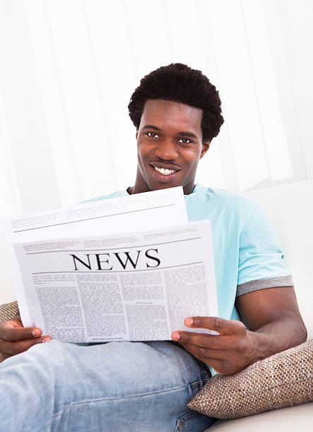 istock Young African Man Reading Newspaper 505872277