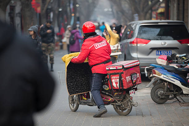 baidu entrega a nanluoguxiang em uma bicicleta elétrica em beijing - dongcheng district - fotografias e filmes do acervo