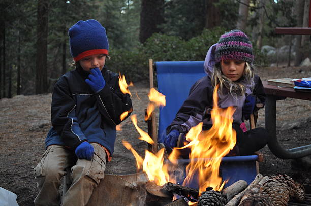 Kids sitting around a campfire stock photo