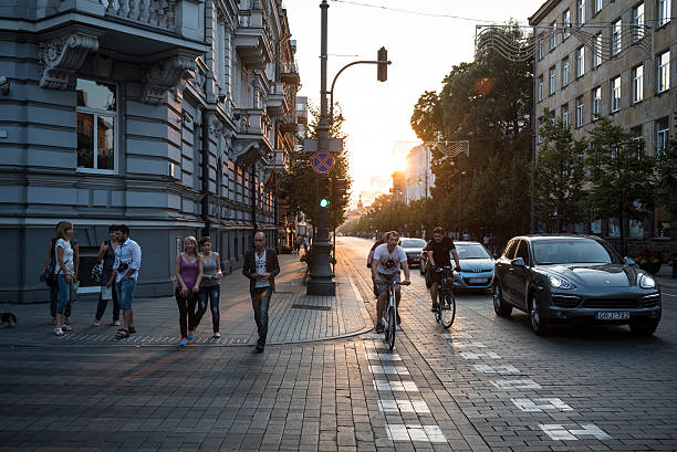Vilnius, Lithuania - August 6, 2015: Pedestrians, cyclists, and cars move forward on a green light on Gediminas Avenue (Gedimino prospektas), the main street in Vilnius, Lithuania.