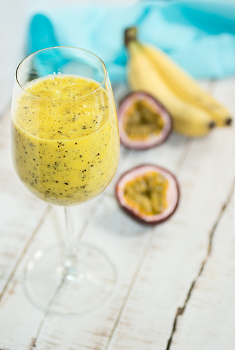 Vibrant yellow banana-passion fruit drink, healthy background