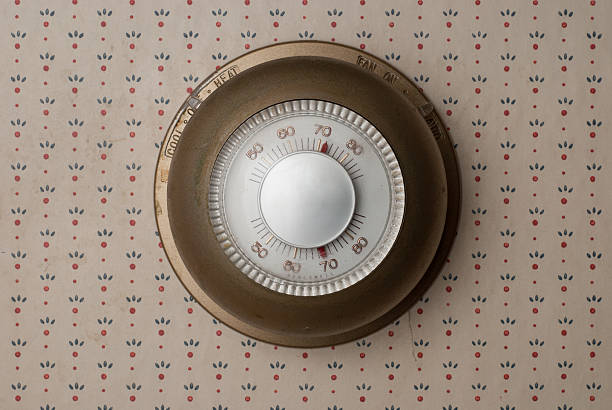 Old Thermostat Old fashioned, outdated thermostat on old wallpaper thermostat photos stock pictures, royalty-free photos & images