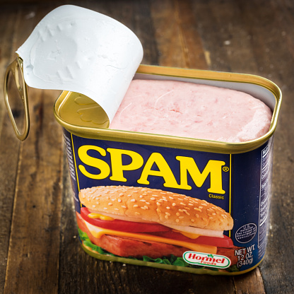Miami, Florida, USA - May 31, 2015: Open 12 Ounces can of SPAM. Spam stands for Spiced Pork and Ham, which is a canned precooked meat product. It is made by the Hormel Foods Corporation and was introduced in 1937.