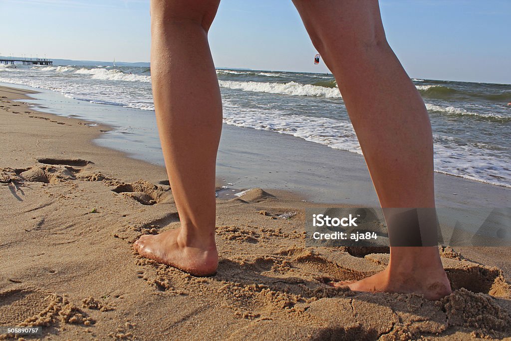 Women walks on the beach A young woman walking on the sand. Active Lifestyle Stock Photo