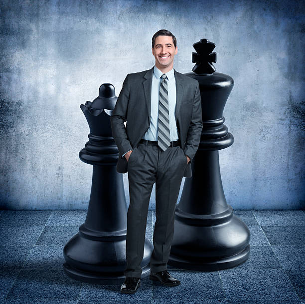 istock Businessman Standing In Front Of Two Large Chess Pieces 505890948