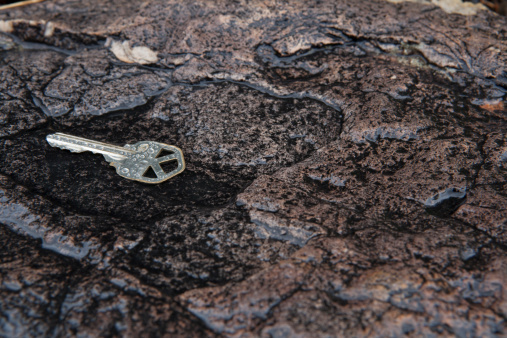 Lost house key on rock in the rain