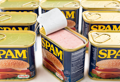 Miami,Florida, USA - May 31, 2015: Open Can of SPAM and seven unopened cans of SPAM isolated on a white background. Spam stands for Spiced Pork and Ham, which is a canned precooked meat product. It is made by the Hormel Foods Corporation and was introduced in 1937.