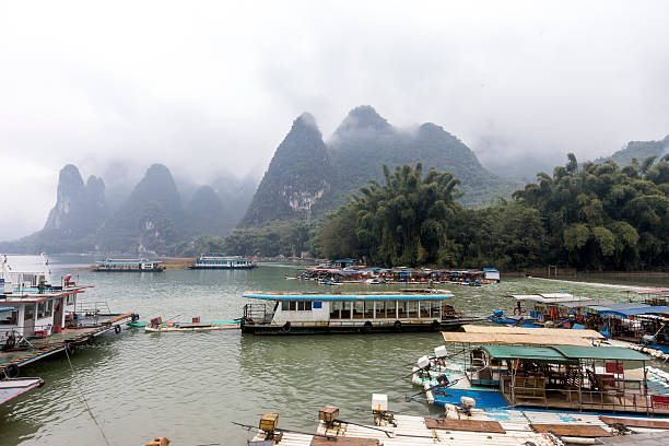Habor at Xinping Ancient Town, Guilin, Guangxi, China Habor at Xinping  Ancient town.  Ancient town tourist attraction . A lot boat parking here. Mist mountains on the back ground. hillary clinton stock pictures, royalty-free photos & images