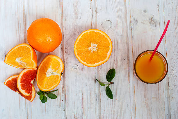 istock glass orange juice and a group oranges on white board 505898258