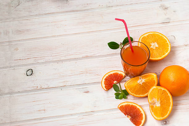 istock glass orange juice and a group oranges on white board 505898762