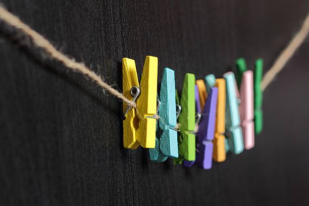 istock small colored clothespins on a rope on black background 505916678