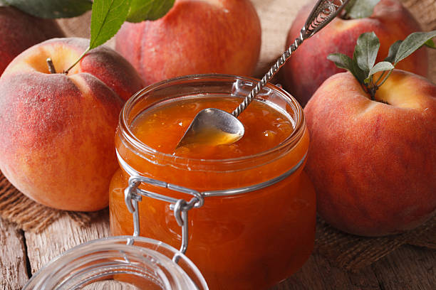 istock Fresh peach jam in glass jar closeup on table. Horizontal 505917804