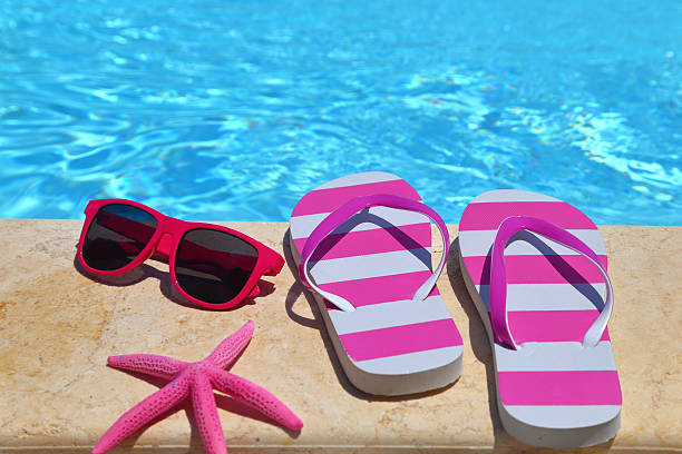 istock Flip flops, glasses and starfish by the poolside 505920427