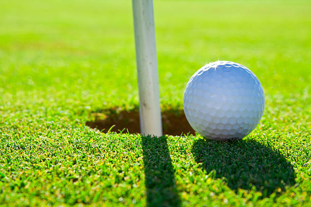 istock golf ball on green next to hole 505922524