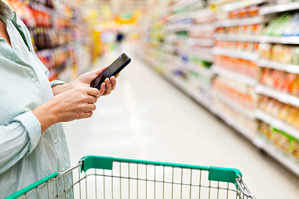 istock Woman using smartphone in supermarket 505923024