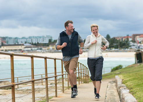 Australian couple running by the beach