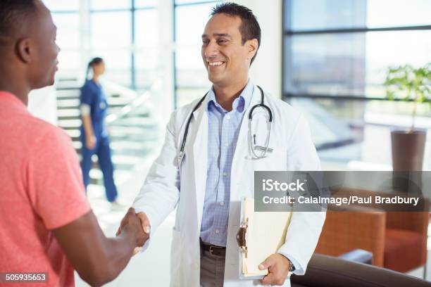 Doctor And Patient Shaking Hands In Hospital Stock Photo - Download Image Now - Doctor, Lab Coat, Patient