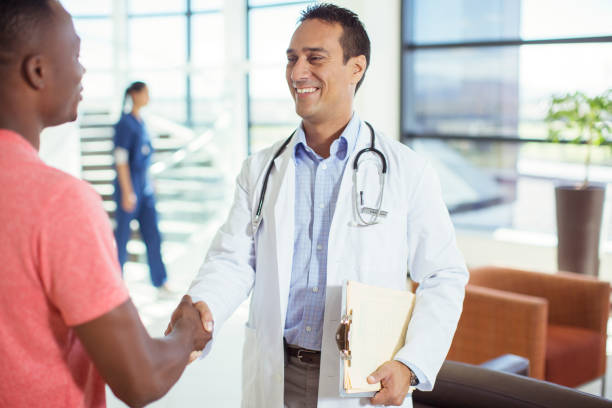 doctor and patient shaking hands in hospital - doctor patient greeting talking imagens e fotografias de stock