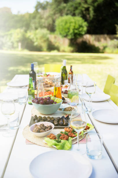 тарелки с едой на столе на открытом воздухе - feast day стоковые фото и изображения