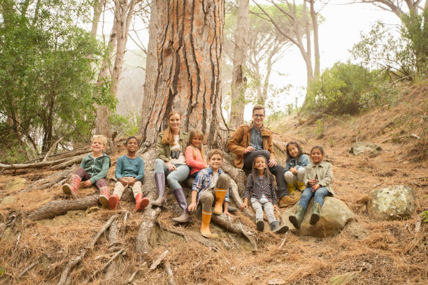 Family enjoying nature, mother and children playing in forest woods.