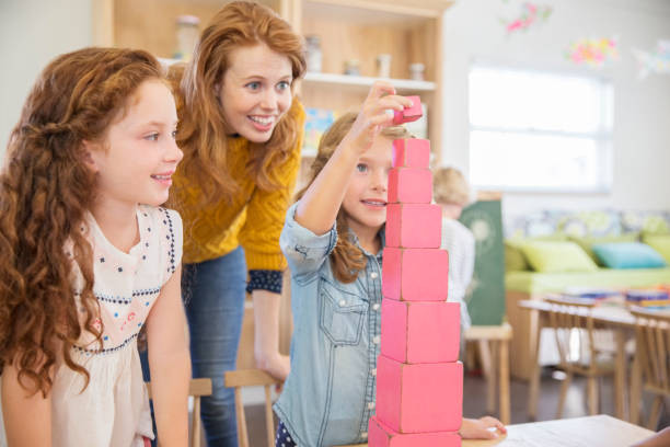 blocchi impilabili di studenti e insegnanti in classe - block togetherness happiness indoors foto e immagini stock