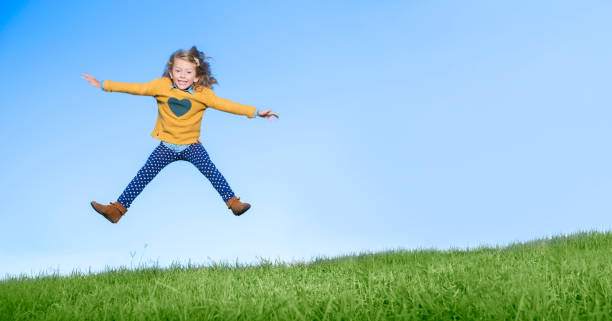 istock Girl jumping for joy on grassy hill 505935957