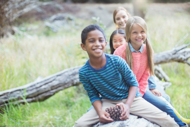 istock Children sitting on log in forest 505935973