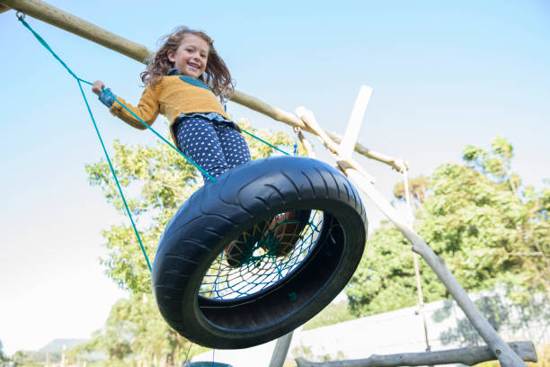 девушка играет на шинах - tire swing стоковые фото и изображения