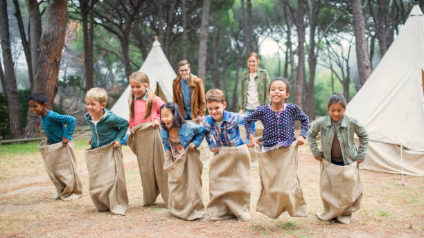 kinder mit sackrennen auf dem campingplatz - field trip stock-fotos und bilder