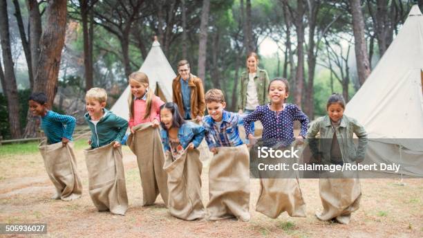 Children Having Sack Race At Campsite Stock Photo - Download Image Now - Summer Camp, Child, Camping