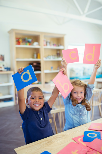 Happy group of kids having fun at elementary school while playing in class