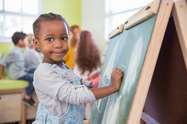 istock Girl drawing on chalkboard in classroom 505936183