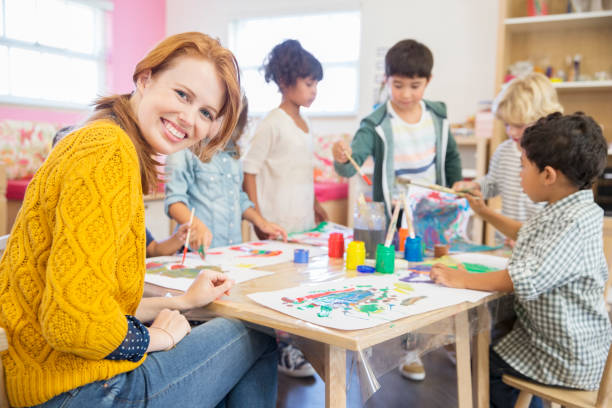 Teacher and students painting in classroom  preschool building stock pictures, royalty-free photos & images
