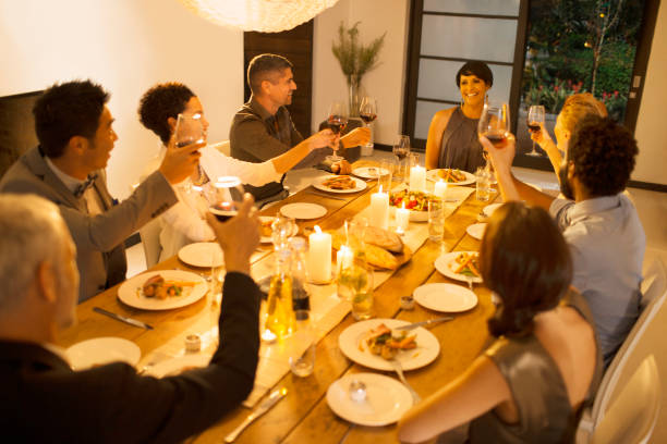 istock Friends toasting each other at dinner party 505936275