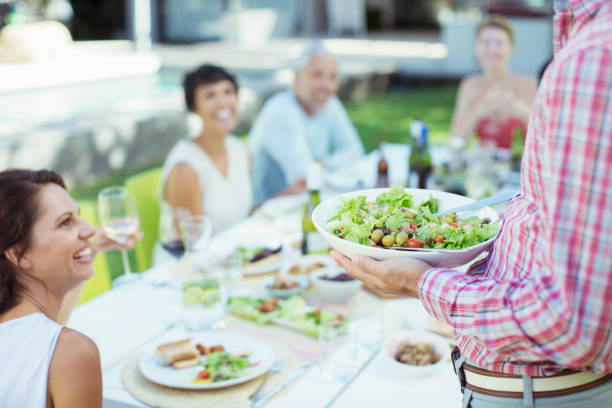 istock Man serving friends at table outdoors 505936333