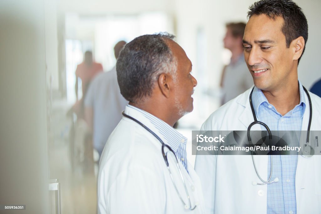 Doctors talking in hospital hallway  Doctor Stock Photo