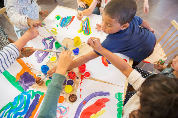 niños pintando en clase - hands in the middle fotografías e imágenes de stock