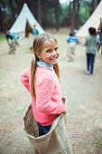 istock Girl smiling in sack at campsite 505936359