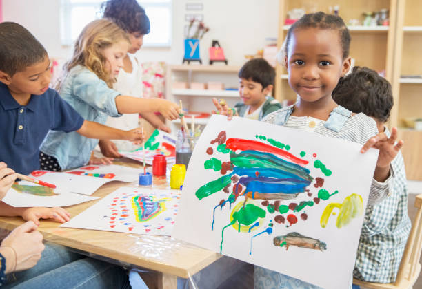 estudiante mostrando pintura con los dedos en el aula - elementary student fotos fotografías e imágenes de stock