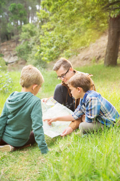 istock Students and teacher reading map in field 505936811