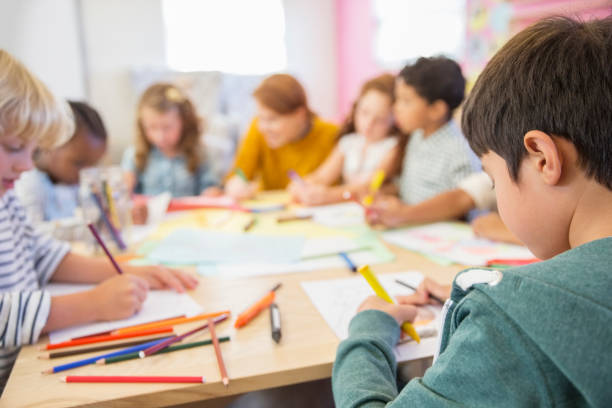 teacher and students drawing in classroom - multi ethnic group concentration student asian ethnicity imagens e fotografias de stock