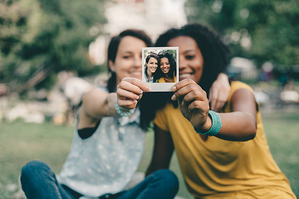 Friends showing instant photo Girls showing instant photo selfie together gay couple photos stock pictures, royalty-free photos & images